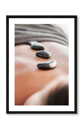 Woman, rocks and back in spa relaxation for treatment, stress relief or massage at resort. Female relaxing with hot stone in physical therapy for skincare, body healing or zen wellness at salon