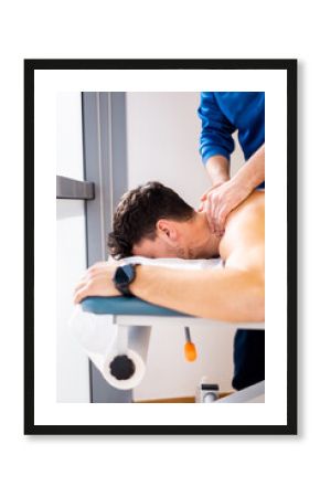 Vertical photo of an unrecognizable physiotherapist performing a massage on a man's neck inside a clinic. Decontracting massage. Stress release. Nerve lash in men.