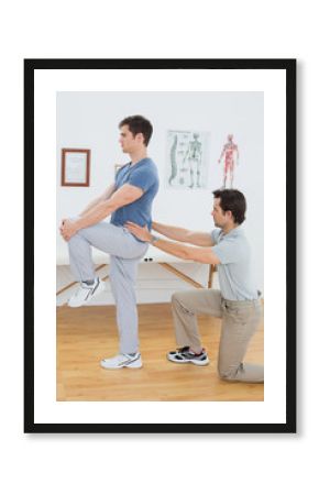 Side view of a male physiotherapist examining mans back
