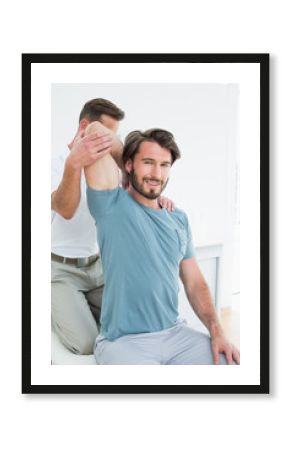 Male physiotherapist stretching a young man's arm