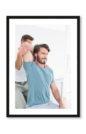 Male physiotherapist stretching a young man's arm