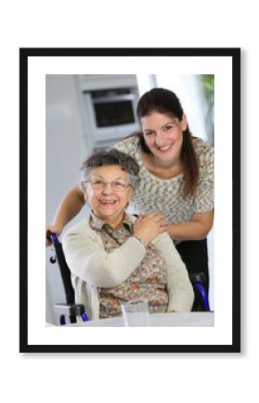 Portrait of elderly woman in wheelchair with homecarer