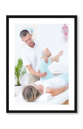 Physiotherapist doing leg massage to his patient