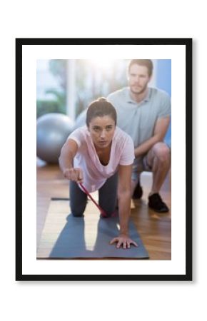 Physiotherapist assisting a female patient while exercising