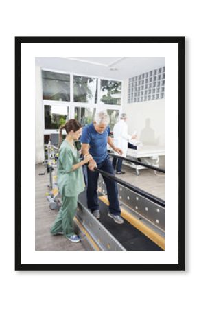 Physiotherapist Standing By Patient Walking Between Parallel Bar