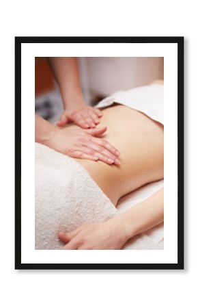 A woman receiving a belly massage at spa salon