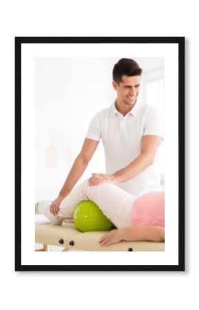 Smiling physiotherapist and elderly patient