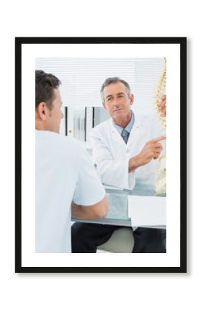 Doctor explaining spine to a patient in office