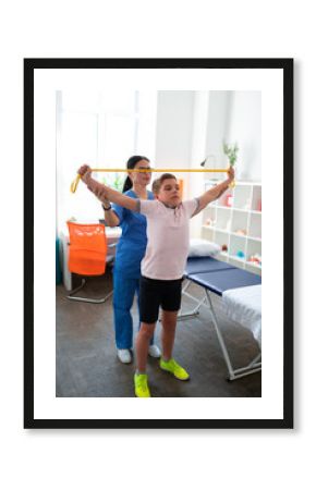 Serious little boy raising his hands with yellow rope