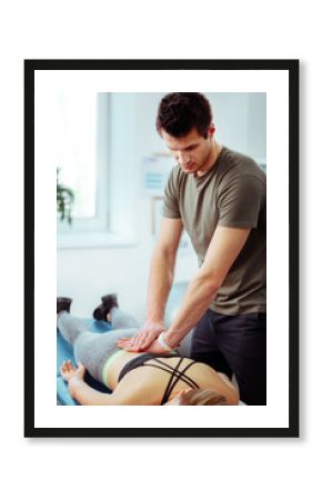 Nice professional masseur doing a back massage