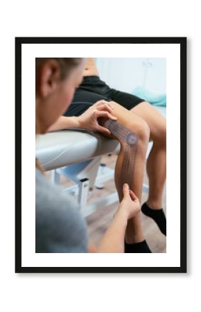 Photo detail of a woman physiotherapist measuring a plastic prosthesis on a patient's knee. Concept of muscle health and relaxation.