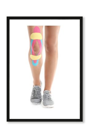 Sporty woman with physio tape applied on knee against white background