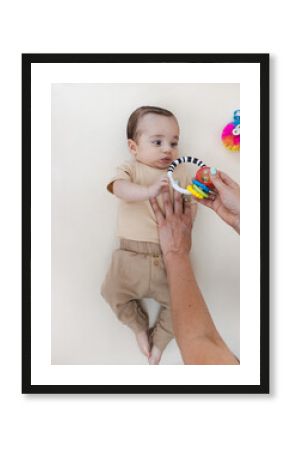Pediatric physiotherapist uses sensory toy to engage baby and support visual tracking and upper body motor response