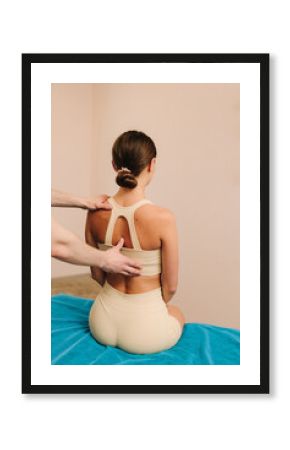 Physiotherapist is treating upper back pain for female patient. Improving back mobility in clinic. Doing osteopathy to reduce pain and muscle tension.