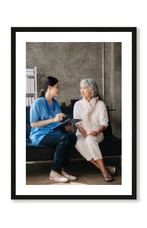 Asian caregiver doctor examine older patient woman therapist nurse at nursing home taking care of senior elderly woman sit on sofa