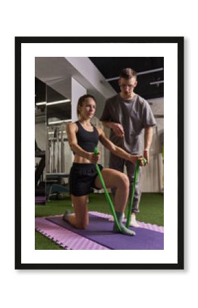 Rehabilitation session with physiotherapist instructing patient performing strength exercises with green resistance bands. Concept of rehabilitation, recovery, healthcare, physical therapy