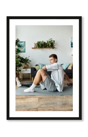 Young man with prosthetic leg stretching at home among plants and cozy decor
