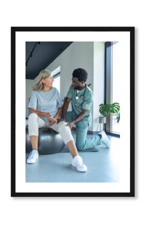 Orthopedic specialist helping patient with knee flexion exercises focusing on joint recovery
