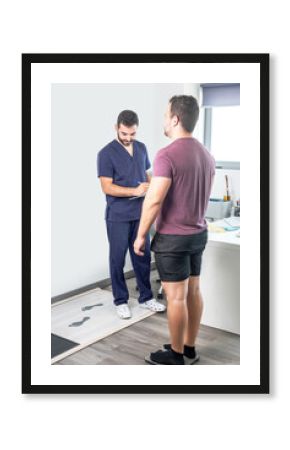 Physiotherapist performing a check-up on a patient while being weighed on a scale.