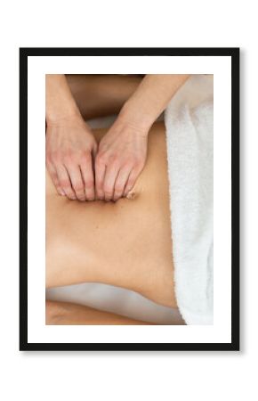 Hands of physiotherapist checking diastasis recti on belly of postpartum woman