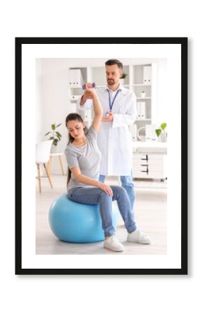 Male physiotherapist working with young woman in rehabilitation center