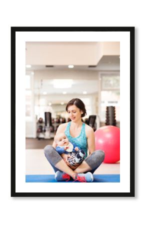 Portrait of new mom on group exercise class in gym. Moms staying active while boding with babies.