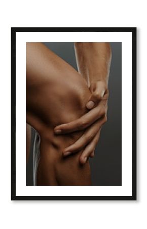 primer plano de manos de una persona que se coge la rodilla con las manos a causa del dolor 