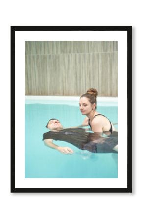 Two people in pool. Watsu man. Blue water rehabilitation massage. Aqua therapy exercise. Physio medical fitness. Sport spa relax. Swim gym class. Adult rehab physiotherapy