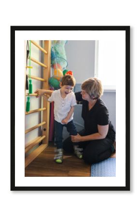 Cute young boy with cerebral palsy engages in rehabilitation exercises with a supportive physiotherapist in rehab clinic for children