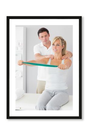 Attractive physiotherapist correcting position of patient