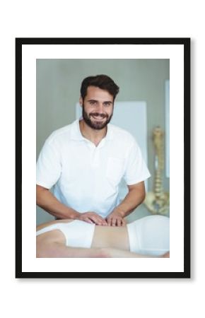 Smiling physiotherapist giving back massage to a woman
