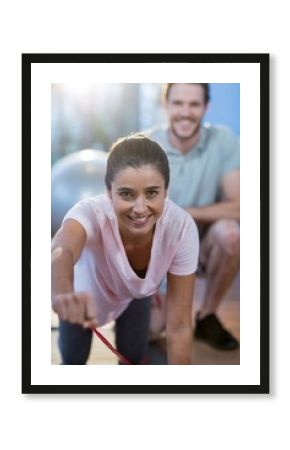 Physiotherapist assisting a female patient while exercising