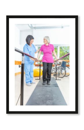 Elderly lady with walking problems training on the platform helped by the physiotherapist