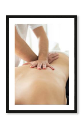 Young physiotherapist doing a back treatment to the patient in a physiotherapy room.