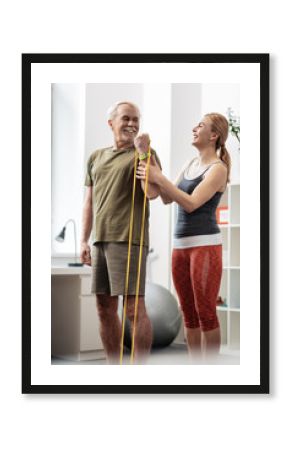 Delighted nice man exercising with a rubber band