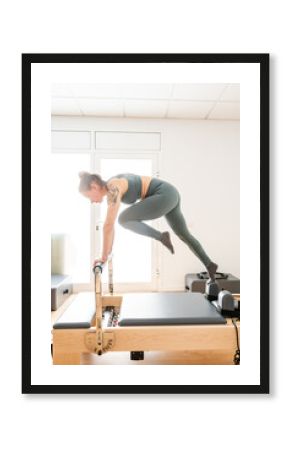 Adult Performing a Dynamic Exercise on a Pilates Reformer in a Bright Studio Setting