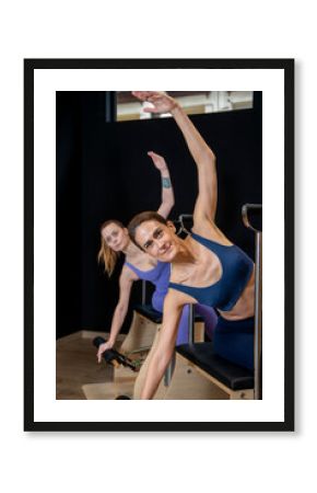 Women doing pilates exercises on chair using special equipment