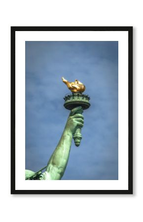 Closeup of the torch of Lady Liberty on a cloudy day