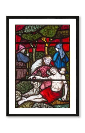 LONDON, GREAT BRITAIN - SEPTEMBER 19, 2017: The Parable of the Good Samaritan  on the stained glass in St Mary Abbot's church on Kensington High Street.