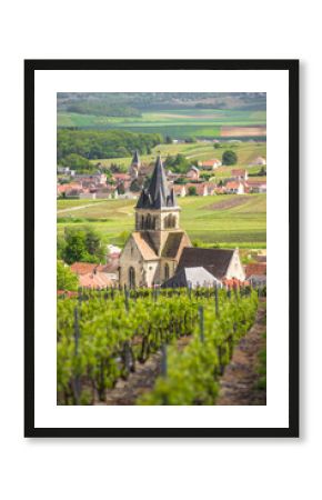Ancient stone church with tower in vineyard field in Champagne region, France