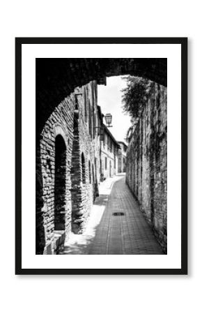 Picturesque medieval narrow street of San Gimignano old town, Tuscany, Italy. Black and white image.