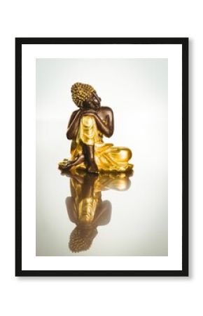 Buddha statue with reflection on table