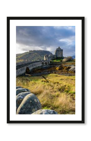 Majestic Eilean Donan castle on beautiful autumn day - with sunny foreground, dramatic sky and amazing scenery