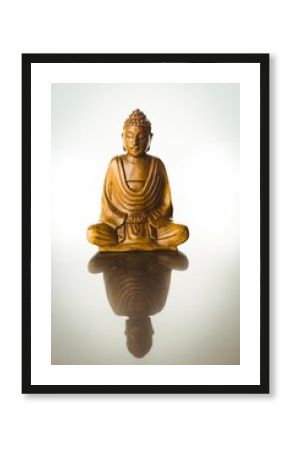 Buddha statue with reflection on table