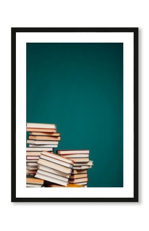 many stacks of educational books to teach in the school library on a green background