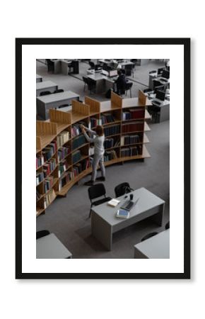 Woman at bookshelf in library