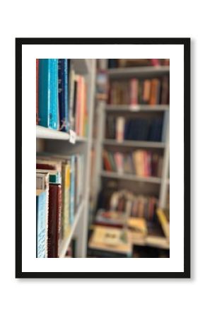 A close-up view of colourful books on a library shelf, with blurred shelves in the background, evoking the timeless charm of a cosy reading space.