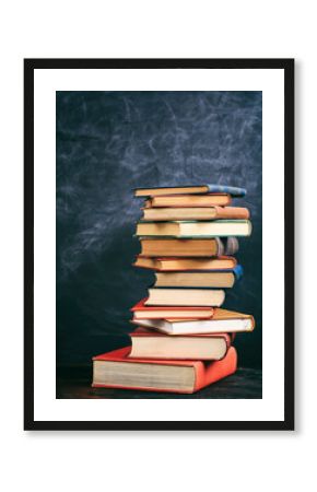 Vintage books stack on blackboard background