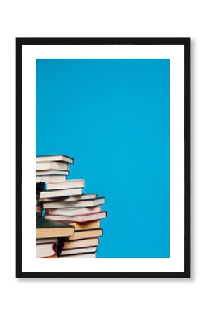 stacks of books for education in the college library on a blue background place for inscription