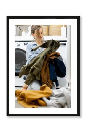 Housewife sorts dirty clothes in the laundry
